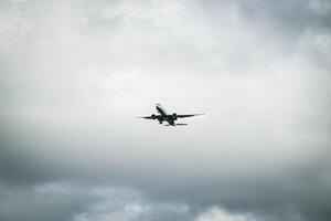 White passenger airplane flying in the sky amazing clouds in the background photo