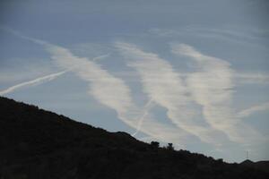 cloud streaks in the sky above the mountains photo