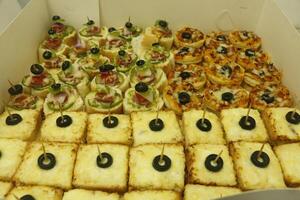 box full with snacks, little pizza, cheese bread photo