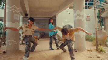 Three young adults dancing joyfully under an urban bridge, showcasing freedom and youth culture. video