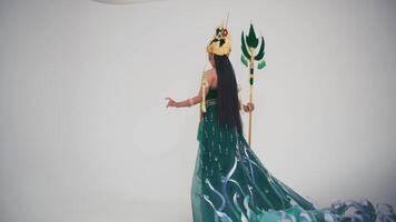 Woman in elaborate costume with mask and spear on a plain background. video