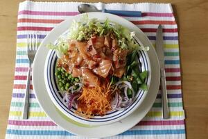 poke bowl with sugarsnaps, peas, red onion, carrot salad, salmon photo