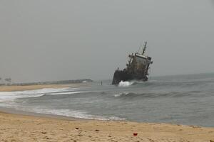 shipwreck against which the waves crash, cotonou, benin photo