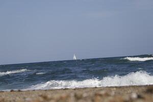 sailboat at sea, waves on the coast photo