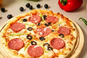 Delicious Pizza on Wooden Plate photo