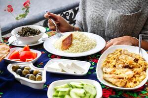 persona sentado a mesa con platos de comida foto