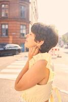 a girl with a short haircut in a yellow dress on the sun drenched streets of Copenhagen photo