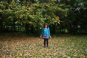 niña en un vestir con globos es jugando en el otoño jardín foto