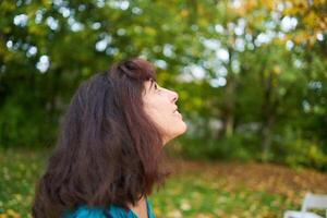 a girl in a dress with balloons is playing in the autumn garden photo