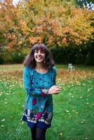 a girl in a dress with balloons is playing in the autumn garden photo