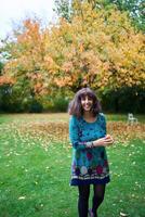 a girl in a dress with balloons is playing in the autumn garden photo