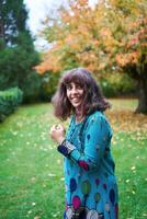 a girl in a dress with balloons is playing in the autumn garden photo