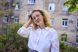 middle age woman in 70s, 80s style clothes with a coffee stain on her blouse in front of gray houses of the 70s photo