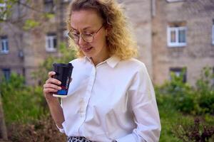 middle age woman in 70s, 80s style clothes spilled coffee on herself during a break outside photo