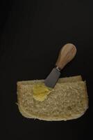 mantequilla ghee en un transparente tarro con hecho en casa un pan en un negro antecedentes foto
