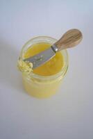 butter ghee in a transparent jar with homemade bread on a white background photo