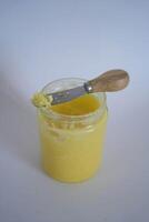 butter ghee in a transparent jar with homemade bread on a white background photo