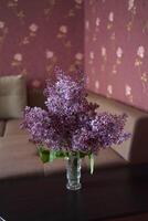 a bouquet of lilacs in a crystal vase in the interior photo