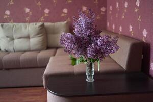 a bouquet of lilacs in a crystal vase in the interior photo