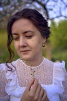 hermosa mujer en blanco Clásico vestir con tren en primavera jardín a puesta de sol foto