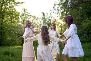 cinco mujer de diferente siglos son dando vueltas en un danza foto