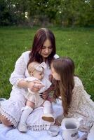 sisters of different ages hug each other tenderly on a picnic in the garden photo