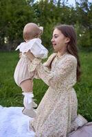 sisters of different ages hug each other tenderly on a picnic in the garden photo