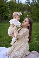 sisters of different ages hug each other tenderly on a picnic in the garden photo