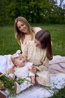 the mother combs the older daughter's hair, and the older daughter combs the younger daughter's hair photo