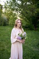 un retrato de un hermosa joven mujer con un ramo de flores de lilas foto