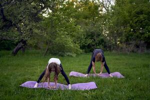 un mujer y niña hacer yoga y meditar en naturaleza foto