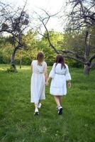 a mother and her teenage daughter are hugging and playing in the garden photo