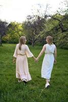 two women hug and pose against the background of nature photo