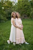 two women hug and pose against the background of nature photo