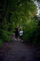 mother and daughter run together along a green alley photo