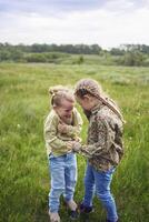 sisters hug and protect each other from the wind in the field photo