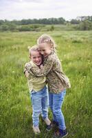 sisters hug and protect each other from the wind in the field photo