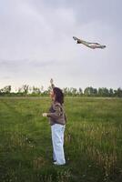 two little sisters and mother run and launch a kite in a field photo