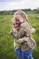 sisters hug and protect each other from the wind in the field photo