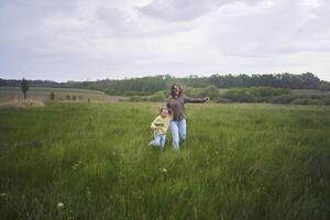 two little sisters and mother run and launch a kite in a field photo