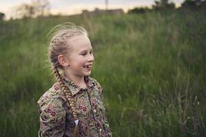 a portrait of a little blond girl in a field photo