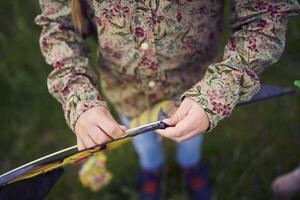 two little sisters repair and fly a kite in a field photo