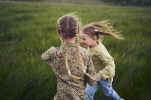 beautiful blonde sisters play with a dandelion in the field photo
