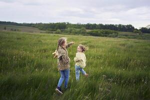 un madre rollos su hijas en su atrás, jugando caballo, Besos y abrazos foto