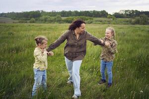 madre rompe arriba el niños quien son luchando en el lluvia en el campo foto