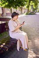 a plus size woman in peach fuzz dress talking on phone in morning city photo