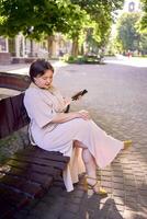 a plus size woman in peach fuzz dress talking on phone in morning city photo