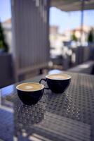 dos tazas de café, latté y capuchino en un mesa en un café foto