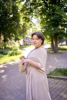 plus size woman in peach fuzz dress with hat having fun on morning city streets photo