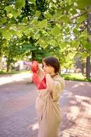 plus size woman in peach fuzz dress and red translucent gloves dancing in the morning city streets photo